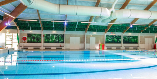 Zwembad Jaspers Winterswijk met Pool Sound Baffles aan plafond en Pool Sound Wall voor betere akoestiek en botanische sfeer.